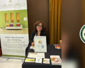 Paola Neglia al banchetto firma libro con il logo della Convention Er-Etici a Milano
